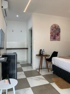 a room with a bed and a desk and a table at 40 40 Accommodation in Matola
