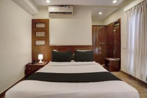 a bedroom with a large white bed in a room at Super Townhouse Koramangala in Bangalore