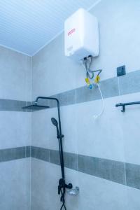 een douche in een badkamer met een lampje aan de muur bij Douglas Home in Ruhengeri
