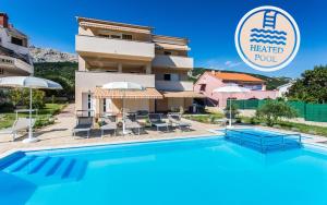 a hotel with a swimming pool in front of a building at Apartments Viktorija 2 in Baška