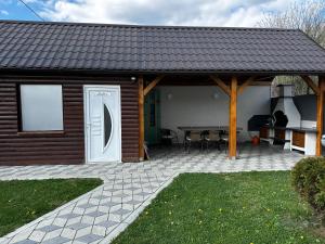 a house with a patio with a table and a grill at Apartmani Lotus Vrdnik in Vrdnik