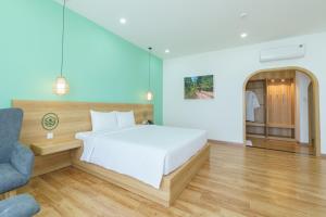 1 dormitorio con cama blanca y pared azul en VinaEcolife Lodge en Ba Tri