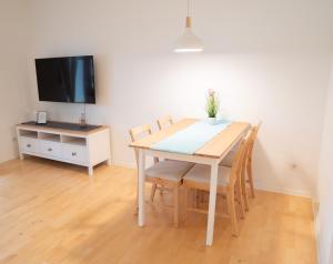 a dining room table with chairs and a tv at Ferienwohnung Montabaur in Montabaur