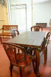 uma mesa de madeira e cadeiras com uma mesa e uma mesa e cadeiras em Green View Lodge em Deniyaya