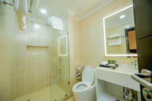 a bathroom with a shower and a toilet and a sink at Urban by CityBlue, Dar es Salaam in Dar es Salaam