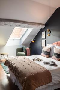 a bedroom with a large bed and a skylight at Hôtel - Restaurant Le Globe in Meursault