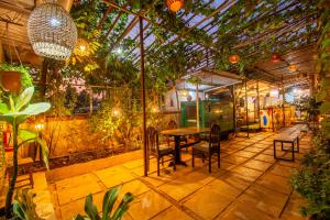 羅納瓦拉的住宿－Flora Ecostay Resort and Spa Lonavala，温室里带桌椅的庭院