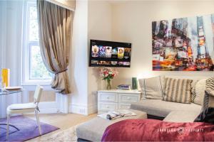 a living room with a couch and a window at Cosy 1bed Garden View Close to Beach and with Parking - Treetop Suite in Bournemouth