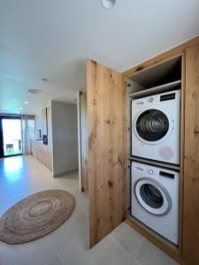 una lavandería con lavadora y secadora en una casa en Casa Vinyanova - Only adults, en Fontanilles