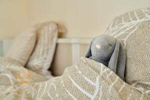 um animal de peluche está escondido debaixo de um cobertor em DUIN 0503 - Appartement voor 8 personen em De Panne