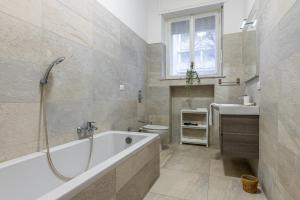 y baño con bañera, aseo y lavamanos. en Cortivo House - Magenta 81, en Milán