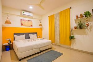 a bedroom with a bed and a yellow wall at Flora Ecostay Resort and Spa Lonavala in Lonavala