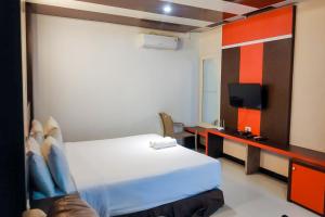 Summarend Hotel RedPartner في Hiliotaluwa: غرفة فندق بسرير وتلفزيون