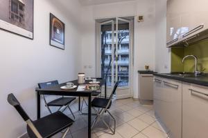 cocina con mesa, sillas y fregadero en Cortivo House - Magenta 81, en Milán