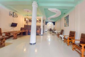 a living room with tables and chairs and a column at Summarend Hotel RedPartner in Hiliotaluwa