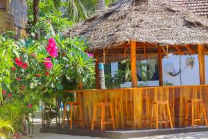 un bar con sgabelli di fronte a una capanna di Lucky Bay ad Arugam