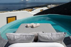 uma mesa com duas toalhas ao lado de uma piscina em Secret Path Luxury Villas em Imerovigli