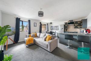 a living room with a couch and a kitchen at Luxury 2 bed, 2 bath apartment in North London in London