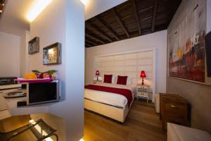 ローマにあるTown House Spagna- luxury Rooms with Jacuzzi Bathのベッドとテレビが備わるホテルルームです。