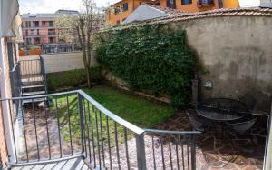 una scala che conduce a un cortile con un tavolo accanto a un muro di K's House a Lecco