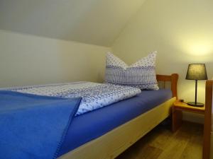uma cama com almofadas azuis e brancas em Ferienwohnung Margret und Kord Hedder em Bispingen