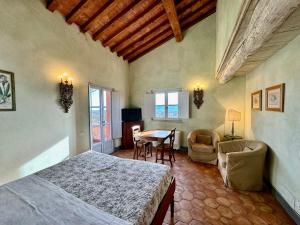a bedroom with a bed and a table and chairs at Agriturismo Monteverde in Castelnuovo Magra