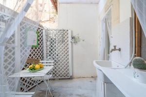 a bathroom with a sink and a table with a bowl of fruit at Giamevi Sicily in Siracusa +18 photos