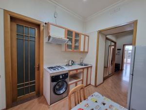 a small kitchen with a stove and a sink at Malakan apartment in Baku