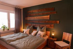 a bedroom with a bed with a wooden accent wall at Ferienwohnung Fichtelsonne in Fichtelberg