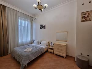 a bedroom with a bed and a dresser and a television at Malakan apartment in Baku