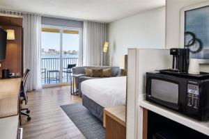 a hotel room with a bed and a tv at Courtyard by Marriott St. Petersburg Clearwater/Madeira Beach in St. Pete Beach