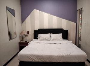 Ένα ή περισσότερα κρεβάτια σε δωμάτιο στο Gangnam Style Residence Mitra RedDoorz near MERR Surabaya