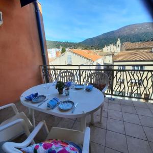 una mesa y sillas en un balcón con vistas en Les Romarins, appartement impeccable et son parking privé, en Nyons
