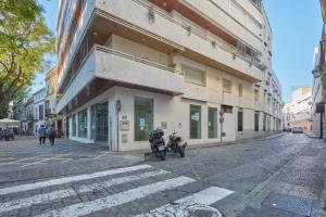 una motocicleta estacionada fuera de un edificio en una calle en corazón de jerez edificio de 1865, en Jerez de la Frontera