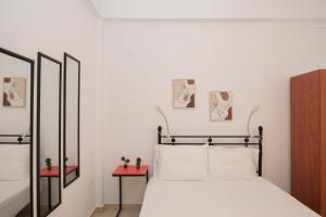 1 dormitorio con cama y espejo en Handakos Loft "by Checkin" en Heraclión