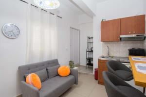 a living room with a couch and two orange pillows at Handakos Loft "by Checkin" in Heraklio