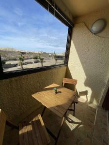 einen Holztisch und Stühle in einem Zimmer mit Fenster in der Unterkunft REF 582 Seignosse Océan, à proximité immédiate de la plage , idéal couple in Seignosse