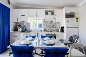 cocina blanca con mesa y sillas en Villa Blue House Garden Hot Tub Konyaalti Antalya, en Antalya