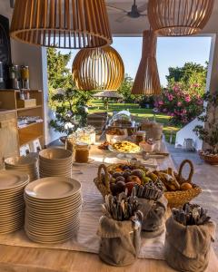 a table with plates and bowls of food on it at LOGOS Beach Village in Theologos