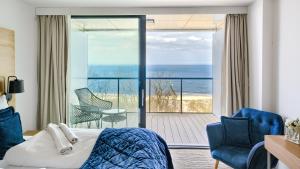 sypialnia z łóżkiem i widokiem na ocean w obiekcie Apartamenty Sun & Snow Seaside Kołobrzeg w Kołobrzegu