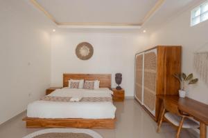 - une chambre avec un lit et un bureau dans l'établissement The Lavana La Bliss Villa North, à Munggu