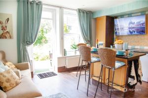 uma cozinha e sala de estar com mesa e cadeiras em Stunning 1 Bed Garden Apartment - City Centre with Parking - The Gardenside Apartment em Bournemouth