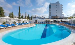 a large swimming pool with blue chairs and umbrellas at Gaia Sun N Blue Hotel in Ayia Napa