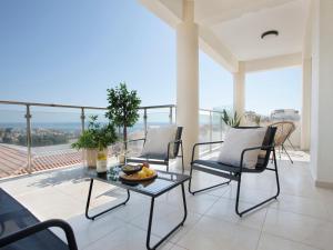 a living room with a table and chairs on a balcony at Sanders Seaview Paphos in Chlorakas