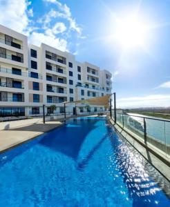 a swimming pool in front of a large building at Beachfront 2BHK apartment at Al Mouj in Seeb