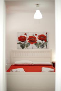 a bedroom with a bed with red flowers on the wall at BlueBay Residence Resort in Taranto