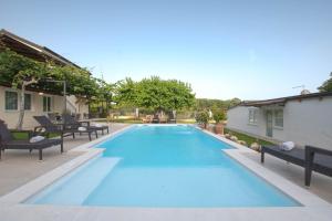 a swimming pool with blue water in a yard at Stancia Rosa - apartment Kiwi in Poreč