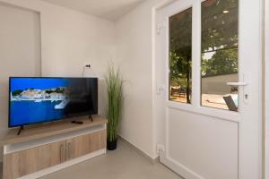 - un salon avec une télévision à écran plat dans un centre de divertissement en bois dans l'établissement Stancia Rosa - apartment Kiwi, à Poreč