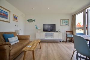 a living room with a couch and a tv at Chalet Fiftynine in Deal