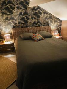 a bedroom with a bed with a black and white wallpaper at Chambre bohème chez Rachel in Pau